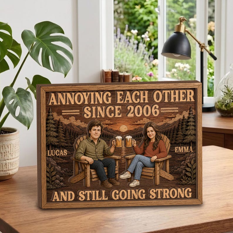May include: A rectangular wooden sign featuring a laser-engraved illustration of two people sitting in chairs, holding mugs, with a forest background. The text reads: ANNOYING EACH OTHER SINCE 2006, LUCAS, EMMA, AND STILL GOING STRONG.