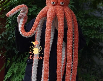 May include: A handmade orange and white crochet octopus hat with multiple tentacles. The hat features two large, expressive eyes and is designed to be worn on the head. The tentacles are long and striped, adding to the whimsical design.