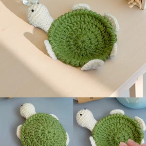 May include: A handmade crochet turtle coaster. The turtle has a green shell, white head, and white flippers. The coaster is designed to protect surfaces from drink condensation. The turtle is approximately 5 inches in diameter.