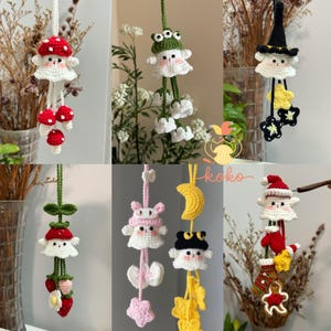 May include: A collection of handmade crochet ornaments, including a mushroom, frog, witch, bunny, cat, and Santa Claus. Each ornament features a whimsical design with vibrant colors and intricate details. The ornaments are suspended by strings, showcasing their decorative nature.