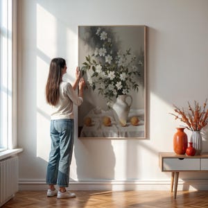 Impresión de arte mural de bodegón floral vintage con flores blancas en jarrón de cerámica y naranjas, elegante decoración rústica para cocina o comedor.