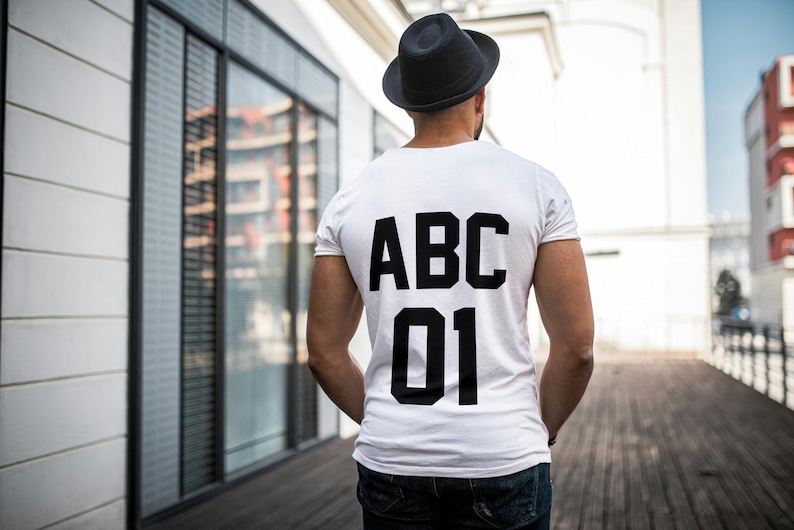 May include: A white t-shirt with black text on the back that says "ABC 01".