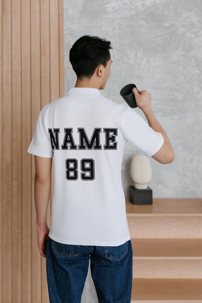 May include: White polo shirt with black text on the back that says "NAME 89".