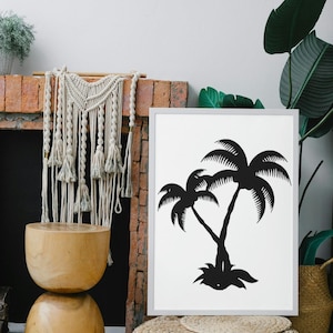 May include: A black and white print of two palm trees in a white frame. The print is hanging on a brick wall above a wooden stool and a woven ottoman.