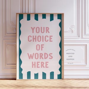 Può includere: Stampa artistica incorniciata con sfondo bianco e strisce verticali verde acqua. Il testo rosa dice "YOUR CHOICE OF WORDS HERE". La stampa è in una cornice di legno, appoggiata a un muro bianco.