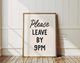 May include: A framed print with a white background and black text that reads "Please Leave By 9PM". The frame is brown wood.