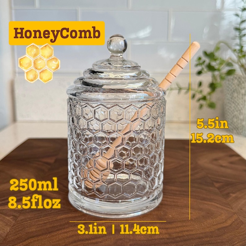 May include: A clear glass honey jar with a honeycomb pattern, a wooden honey dipper, and a glass lid. The jar is 5.5 inches (15.2 cm) tall and 3.1 inches (11.4 cm) wide, holding 8.5 fl oz (250ml). The jar has the word "HoneyComb" in a yellow banner.