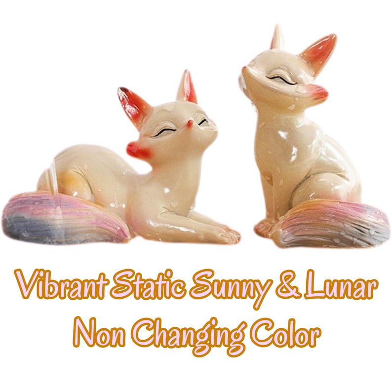 Puede incluir: Dos figuras de zorro de color crema con puntas de orejas naranjas y colas multicolores. Un zorro est&aacute; acostado mientras el otro est&aacute; sentado. El texto debajo dice: Vibrant Static Sunny & Lunar Non Changing Color.