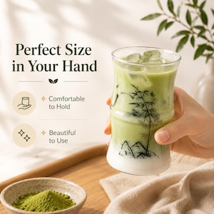 May include: A clear glass tumbler with a bamboo-shaped silhouette, featuring a black ink illustration of bamboo stalks and mountains. The glass is filled with a light green matcha latte and ice cubes. Text on the image reads Perfect Size in Your Hand.