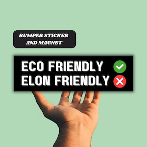 May include: Black and white bumper sticker or magnet with the text "ECO FRIENDLY" with a green checkmark and "ELON FRIENDLY" with a red X.