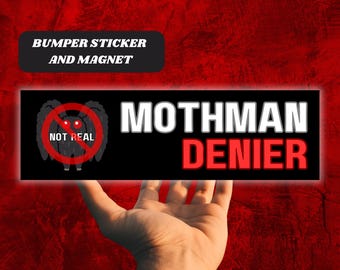 May include: A black bumper sticker and magnet with the text "MOTHMAN DENIER" in white and red. The sticker features a cartoon Mothman image with a red "not real" symbol over it. The background is a textured red.