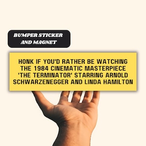 May include: Yellow bumper sticker or magnet with the text "HONK IF YOU'D RATHER BE WATCHING THE 1984 CINEMATIC MASTERPIECE 'THE TERMINATOR' STARRING ARNOLD SCHWARZENEGGER AND LINDA HAMILTON"
