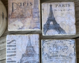 May include: Set of four square coasters featuring vintage Parisian designs. Each coaster has a different image of the Eiffel Tower and the words "Paris" or "Cafe Paris".