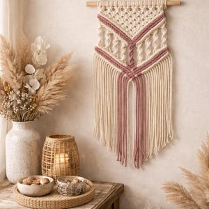 Tapiz de pared bohemio de macramé, hecho a mano en tonos crema y rosa empolvado, con hilo tejido.