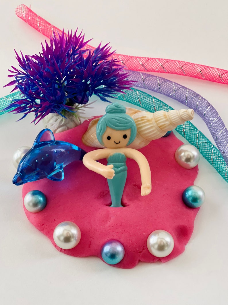 pink play dough with mermaid figurine and gems