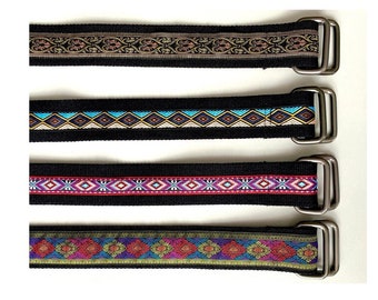 May include: Four black canvas belts with different colored woven patterns and silver buckles.
