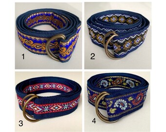 May include: Four different blue woven belts with colorful patterns and a brass buckle. The belts are numbered 1 through 4.