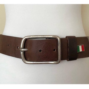 May include: A brown leather belt with a silver buckle and an Italian flag design.