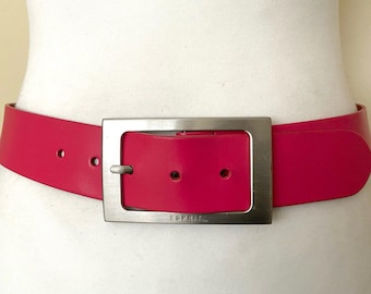 May include: A bright pink leather belt with a silver rectangular buckle that says "ESPRIT" on it.