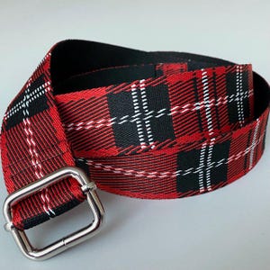Può includere: Una cintura a quadri rossi, neri e bianchi con una fibbia quadrata color argento. La cintura è realizzata in tessuto intrecciato con un classico motivo tartan. La cintura misura circa 3,8 cm di larghezza.