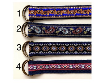 May include: Four different patterned fabric belts with gold metal buckles. The belts are numbered 1 through 4. The patterns include paisley, floral, and geometric designs.