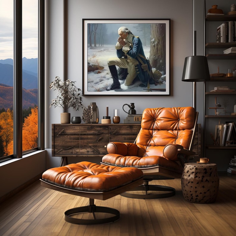 May include: A framed painting of a man in a blue uniform kneeling in a snowy forest, praying with his hands clasped together. The painting is hanging on a wall in a living room with a leather armchair and ottoman.