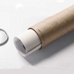 May include: A rolled up print or poster is stored in a brown cardboard tube. The tube has a white label with the text "Assured to Arrive Perfect!" printed on it.