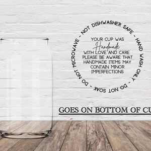 Puede incluir: Una taza de vidrio transparente con una pegatina en blanco y negro en la parte inferior. La pegatina dice "Tu taza fue hecha a mano con amor y cuidado. Ten en cuenta que los artículos hechos a mano pueden contener imperfecciones menores. No usar en el microondas - no apto para lavavajillas - lavar solo a mano - no remojar."