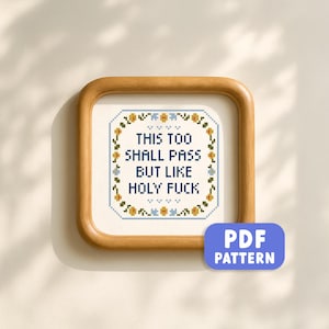 Könnte beinhalten: Ein gerahmtes Kreuzstichbild mit dem Text "THIS TOO SHALL PASS BUT LIKE HOLY FUCK" in einem quadratischen Holzrahmen. Der Kreuzstich hat einen floralen Rand in Blau, Gelb und Grün. Ein blauer PDF-Muster-Button befindet sich unten rechts.