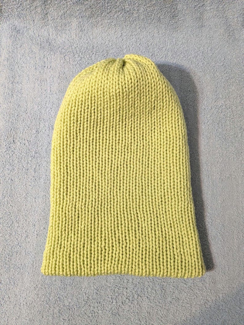 Puede incluir: Un gorro de punto verde claro. El gorro est&aacute; hecho de un hilo suave y texturizado y tiene un patr&oacute;n de punto acanalado. El gorro es de color liso y est&aacute; dise&ntilde;ado para ser usado en la cabeza.