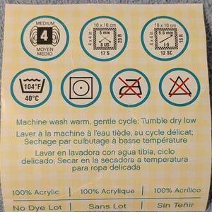 May include: A label with circular icons indicating yarn care instructions. Includes washing, drying, and material information. The label also shows yarn weight and gauge details, with measurements in inches and US sizes.