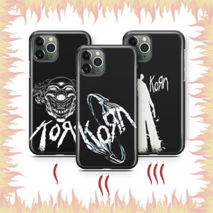 May include: Three black phone cases with different designs. The first case features a clown with the word "Korn" written below. The second case features a skeleton hand with the word "Korn" written below. The third case features a silhouette of a person with the word "Korn" written below.