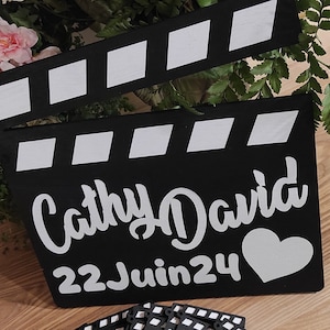 Peut inclure: Clap de cinéma noir et blanc avec le texte "Cathy David 22 Juin 24" et un cœur blanc.