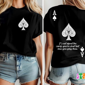 May include: Black t-shirt with a white ace of spades graphic and the text "It's not about the cards you're dealt but how you play them".