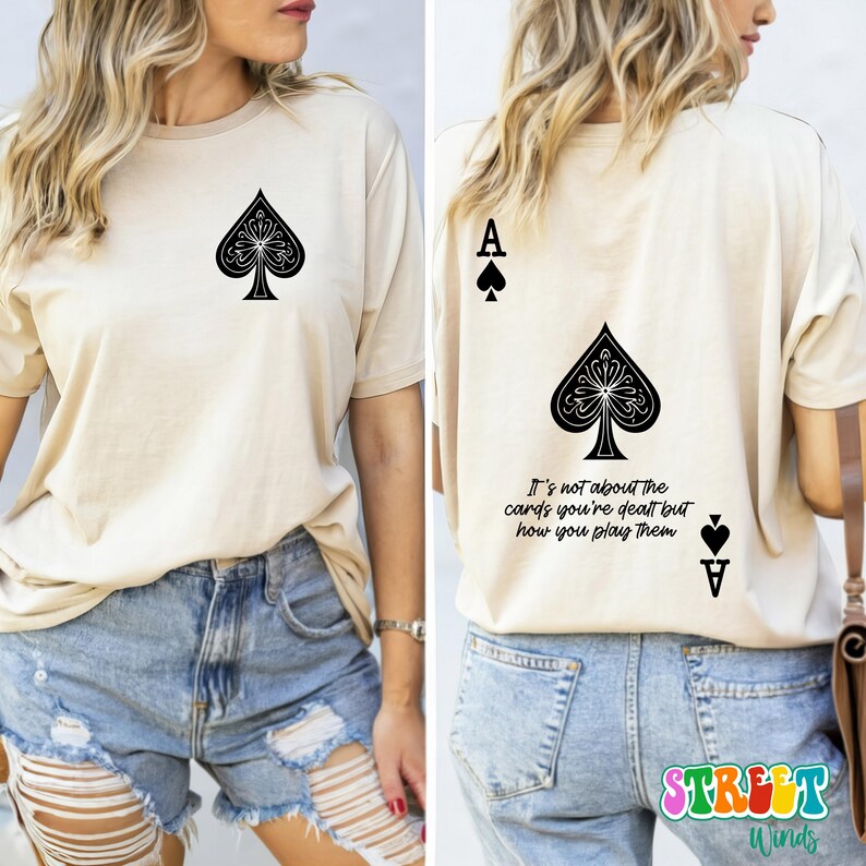 May include: A beige t-shirt with a black ace of spades graphic on the front and the text "It's not about the cards you're dealt but how you play them" and a black ace of spades graphic on the back.