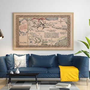 May include: A framed map with a fantasy theme, featuring illustrations of mountains, rivers, and creatures. The map has a parchment-like background with detailed text and decorative borders. It hangs above a blue sofa with a yellow throw blanket.