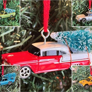 May include: A collection of miniature car ornaments, each with a small, artificial Christmas tree secured to the roof. The cars are in various colors, including red, yellow, blue, and green, and are suspended by red ribbons. The ornaments are set against a backdrop of green Christmas tree branches.