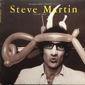 Puede incluir: Portada del álbum con Steve Martin con un sombrero de globos y gafas. El título "Steve Martin" está en amarillo, con "LET'S GET SMALL" debajo. La imagen es un retrato en tonos sepia del comediante.