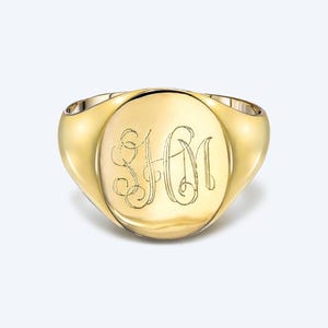 May include: A gold signet ring with an oval top featuring the engraved initials "SHM".