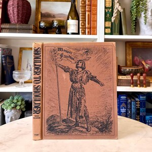 May include: A vintage book titled "Shoulder to Shoulder" with a sepia-toned cover illustration of a woman holding a flag that reads "Woman's Franchise". The book's spine is light brown.