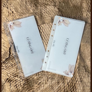 May include: Two clear plastic page protectors with white paper inserts. The inserts feature a floral design and the text "Eating Out" printed on them.