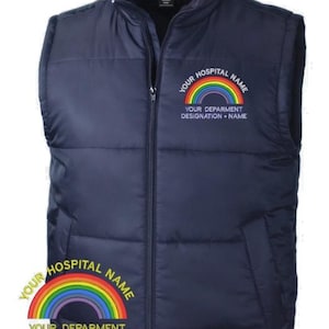 May include: A navy blue puffer gilet featuring a full-length front zip and a high collar. The chest area displays an embroidered rainbow graphic with the text YOUR HOSPITAL NAME and YOUR DEPARMENT DESIGNATION + NAME in white lettering.