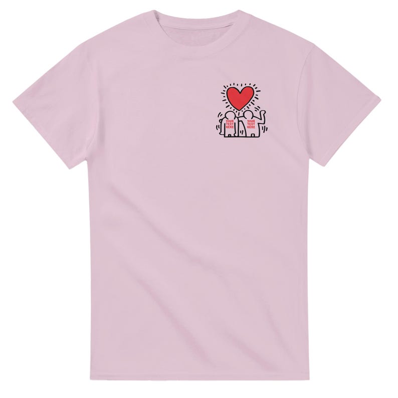 May include: Pink t-shirt with a graphic of two stick figures holding hands under a red heart. The text "YOUR TEXT HERE" is written on the figures.