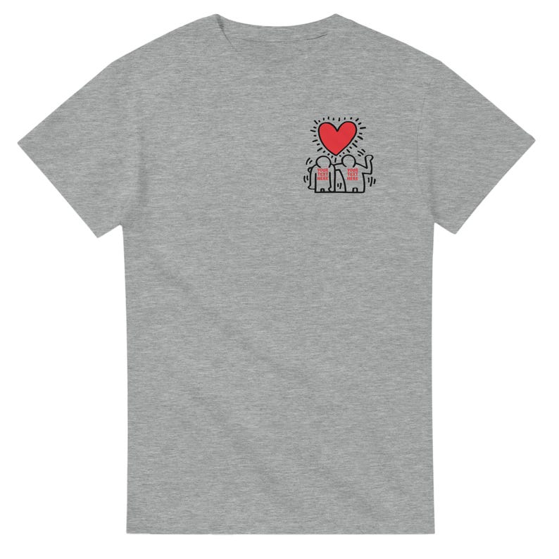 May include: A gray t-shirt with a black and red graphic of two figures holding hands under a red heart. The figures are wearing hats and the heart has a yellow halo.