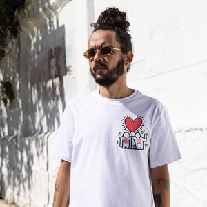 May include: White t-shirt with a red heart and black stick figures with the text "YOUR TEXT HERE" printed on the front.