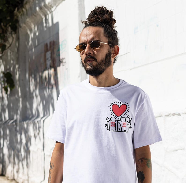 May include: White t-shirt with a red heart and black stick figures with the text "YOUR TEXT HERE" printed on the front.