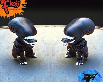 May include: Two black Alien figures with white teeth and feet are displayed. The figures are standing on a gray surface. The figures have the text "Vunk Flexi Authorized Seller" and "DUSTSTARR 3D" on the image.