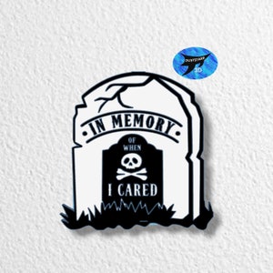Pode incluir: Lápide preta e branca com o texto "In Memory of When I Cared" e uma caveira com ossos cruzados.