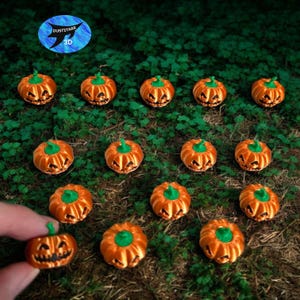 May include: Orange miniature jack-o'-lanterns with green stems are arranged on a bed of green foliage. The pumpkins have carved faces. The image includes a logo that says "duststarr 3D".