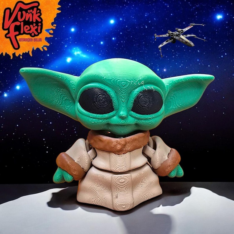 Może przedstawiać: Zielona i brązowa figurka wydrukowana w 3D postaci z franczyzy Star Wars, znanej jako "Baby Yoda" lub "Dziecko". Figurka stoi na białym tle z ciemnoniebieskim tłem z gwiazdami.